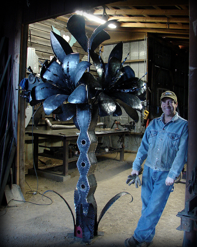 Al Garnto poses with kinetic sculpture, Praise Jesus Tiger Lilies, in his blacksmith shop, Blairsville, Ga.  